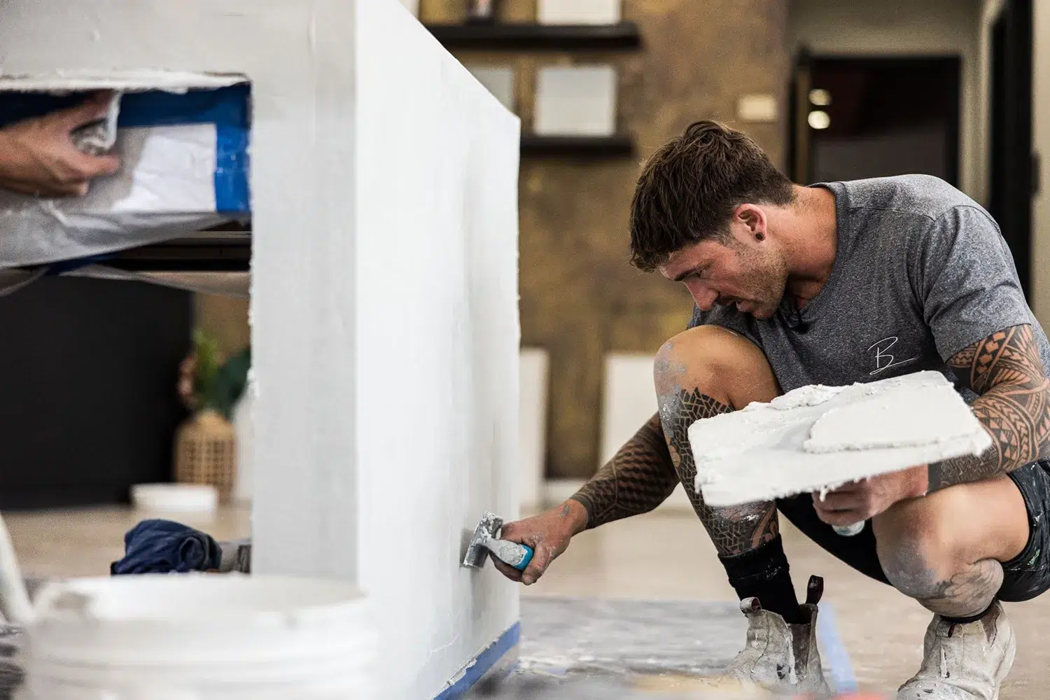 tradesman crouching down rendering a bench.